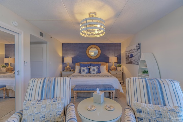 bedroom featuring visible vents and an accent wall