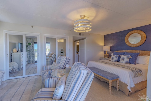 bedroom featuring visible vents, carpet flooring, an accent wall, and access to outside