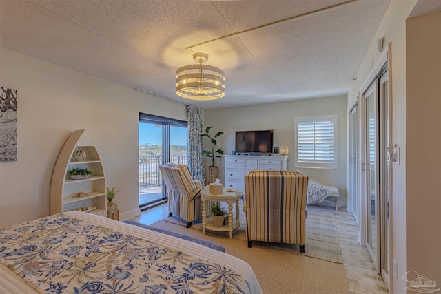 bedroom featuring multiple windows, a textured ceiling, and access to exterior