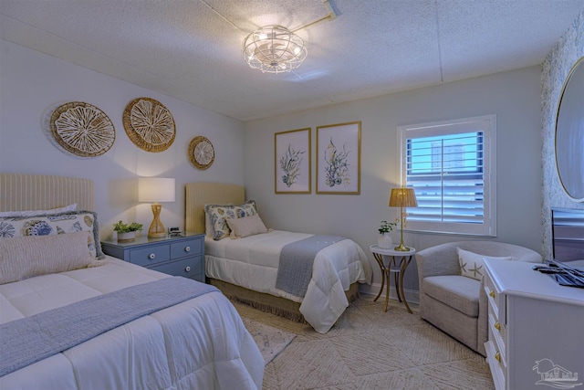 bedroom featuring light colored carpet and a textured ceiling