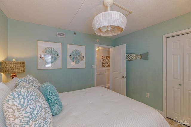 bedroom featuring visible vents, a closet, and a textured ceiling