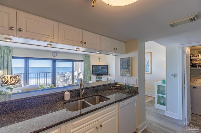 kitchen with a sink, visible vents, dishwasher, and white cabinets