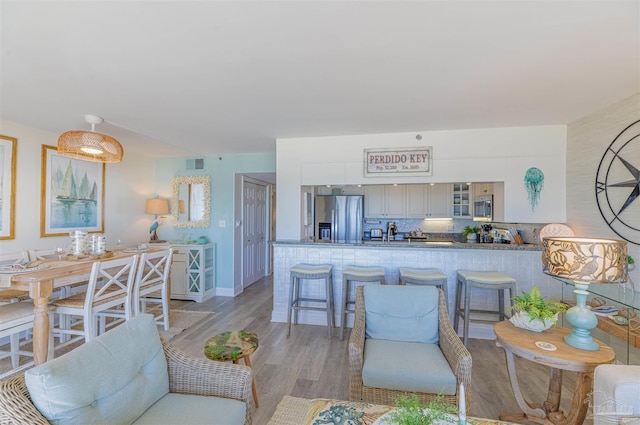 living area featuring light wood-style floors and visible vents