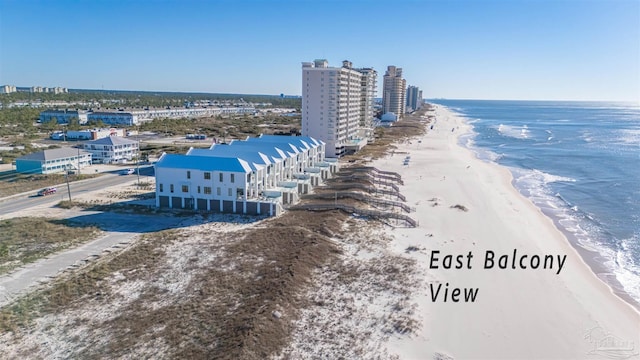 birds eye view of property with a water view, a view of city, and a beach view