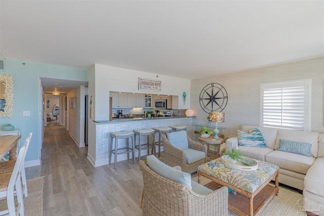 living area featuring light wood-type flooring and baseboards