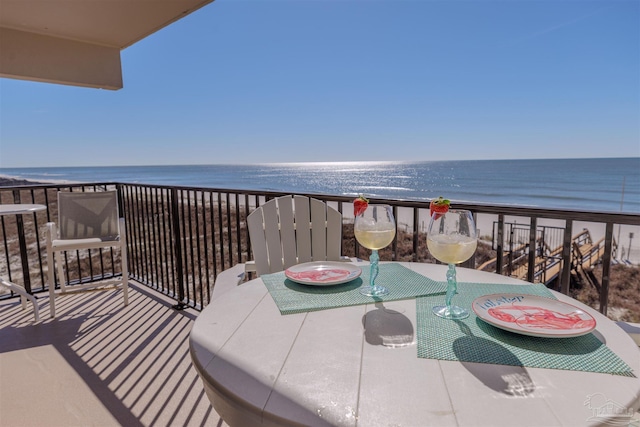 balcony featuring a beach view and a water view