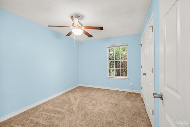 carpeted spare room with ceiling fan