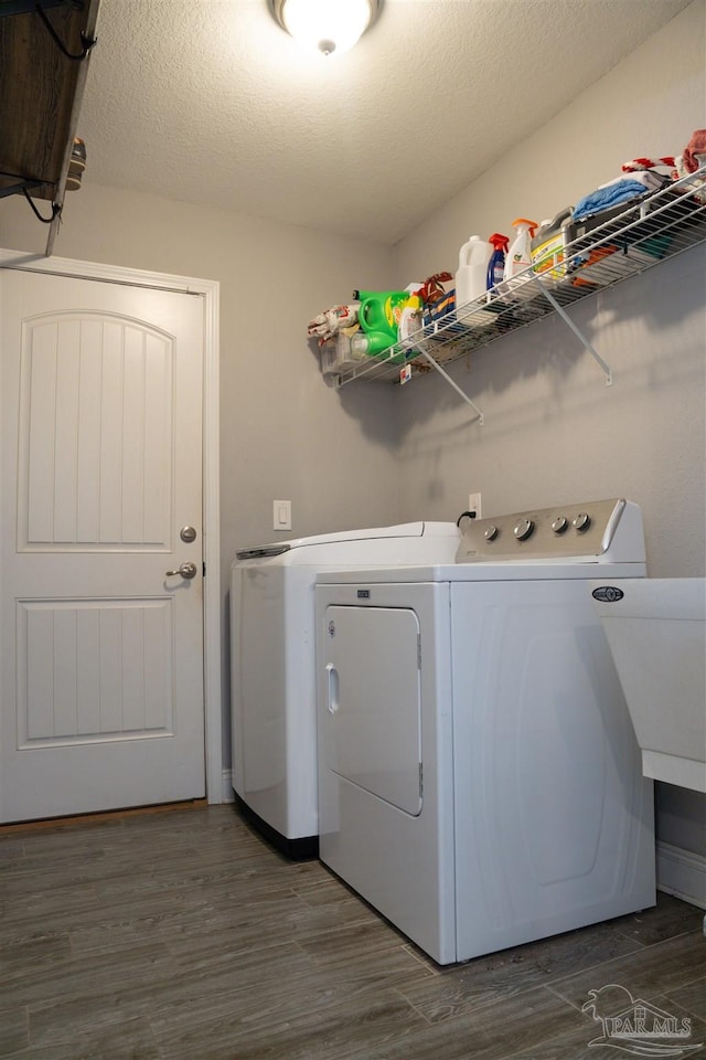 clothes washing area featuring a textured ceiling, dark wood-type flooring, and independent washer and dryer