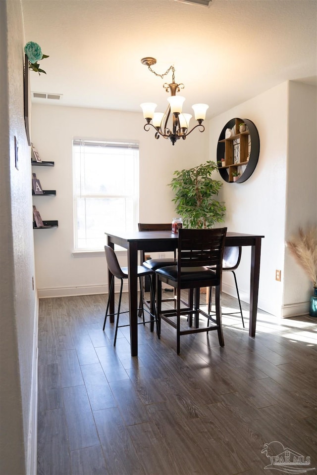 dining room featuring dark hardwood / wood-style floors and a notable chandelier