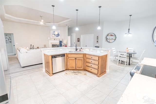 kitchen featuring a center island with sink, dishwasher, a tray ceiling, sink, and ceiling fan