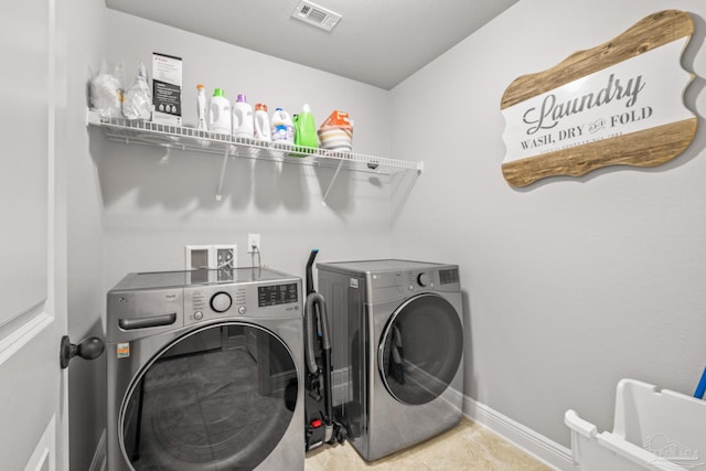 laundry area featuring light tile patterned floors and washing machine and clothes dryer