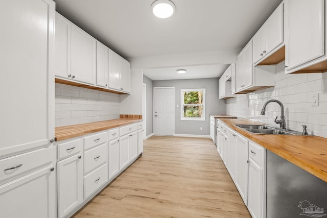 kitchen featuring wood counters, white cabinetry, sink, decorative backsplash, and light hardwood / wood-style floors