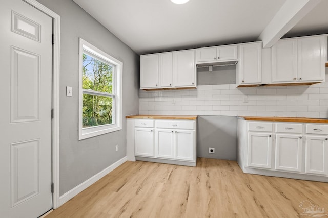 kitchen with butcher block counters, backsplash, light hardwood / wood-style flooring, and white cabinets
