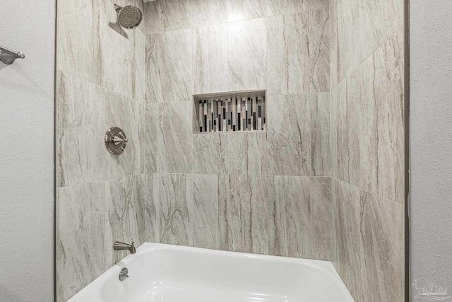 bathroom featuring tiled shower / bath