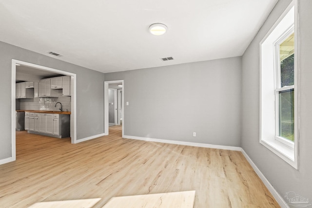 interior space with plenty of natural light, sink, and light hardwood / wood-style floors