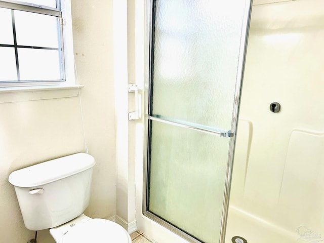 bathroom with an enclosed shower and toilet