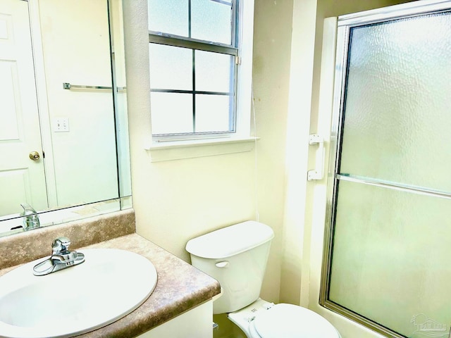 bathroom with vanity, toilet, and a shower with shower door