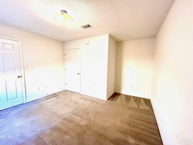 unfurnished bedroom featuring carpet flooring and a textured ceiling