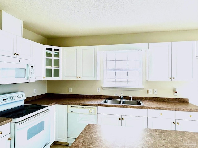 kitchen featuring a textured ceiling, white appliances, white cabinetry, and sink