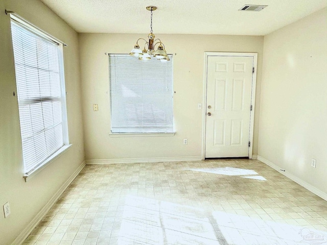 unfurnished dining area featuring an inviting chandelier