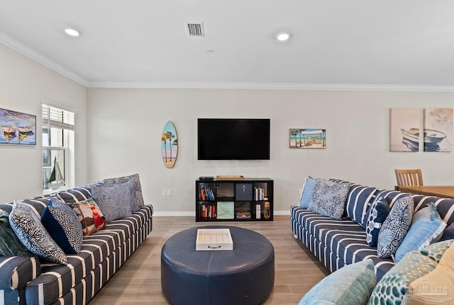 living room featuring visible vents, baseboards, light wood-type flooring, ornamental molding, and recessed lighting