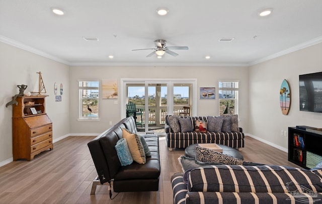 living room featuring visible vents, plenty of natural light, ceiling fan, and wood finished floors