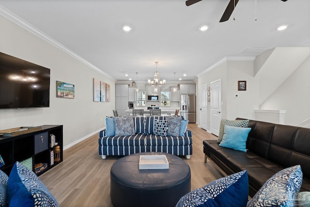 living room featuring baseboards, light wood-style floors, crown molding, and ceiling fan with notable chandelier