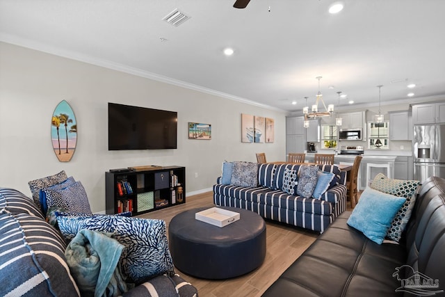 living room featuring light wood finished floors, visible vents, recessed lighting, and crown molding