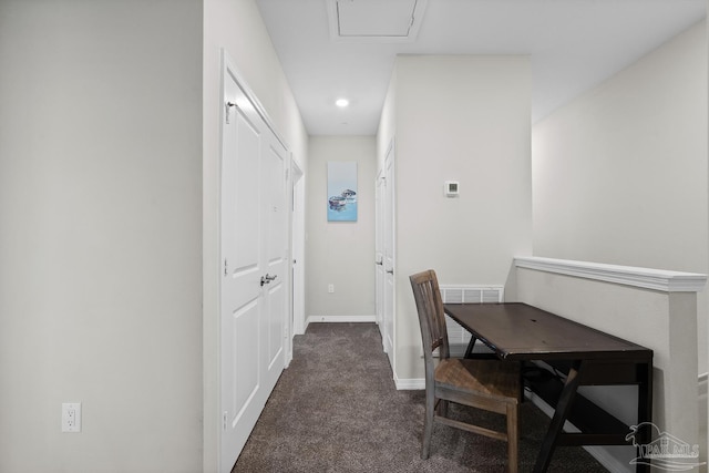 hallway with visible vents, dark carpet, and baseboards