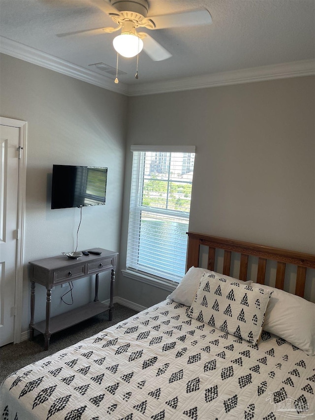 bedroom featuring dark colored carpet, baseboards, ceiling fan, and crown molding