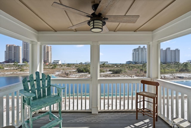 exterior space with a city view, plenty of natural light, a ceiling fan, and a water view