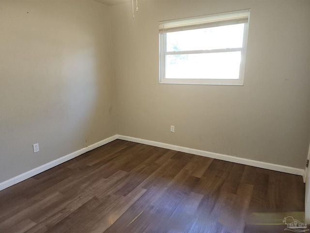 unfurnished room with dark wood-style floors and baseboards