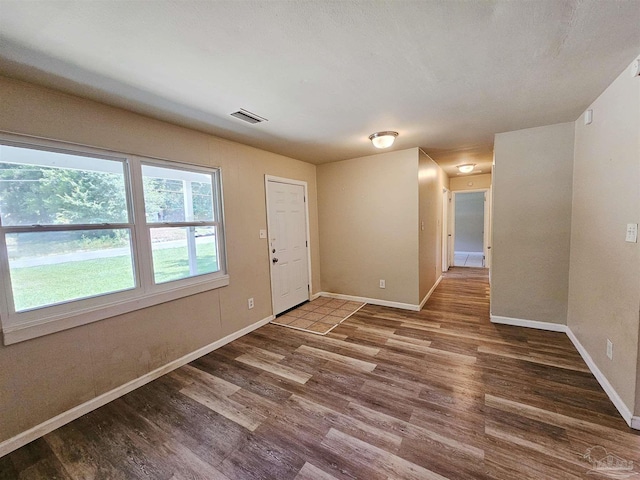 unfurnished room featuring visible vents, baseboards, and wood finished floors