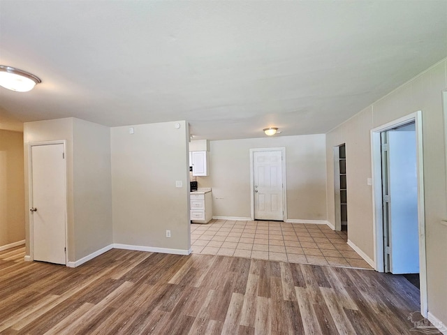 spare room featuring baseboards and wood finished floors