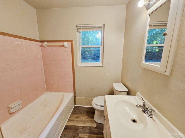 full bathroom featuring toilet, plenty of natural light, vanity, and hardwood / wood-style flooring