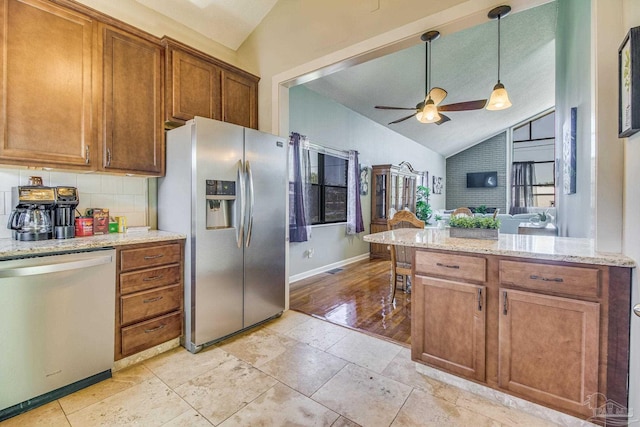 kitchen with tasteful backsplash, stainless steel appliances, light stone countertops, ceiling fan, and pendant lighting