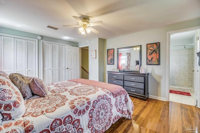 bedroom with multiple closets, connected bathroom, light wood-type flooring, and ceiling fan