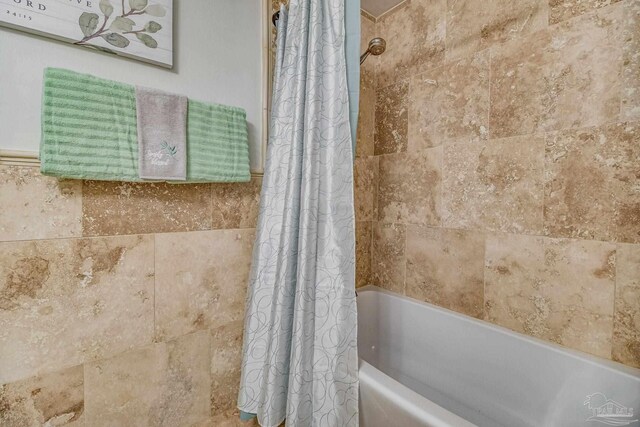 bathroom featuring shower / bathtub combination with curtain