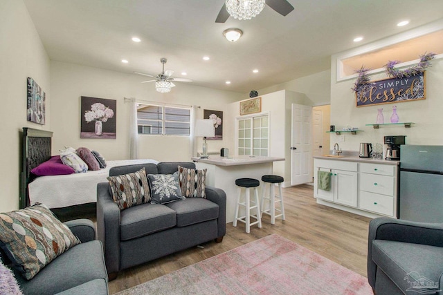 living room featuring ceiling fan, sink, and light hardwood / wood-style floors