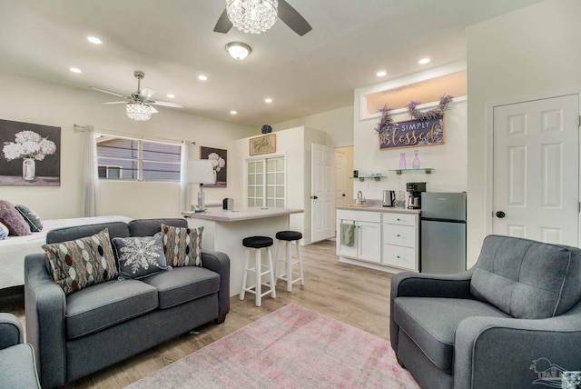 living room with light wood-type flooring, sink, and ceiling fan