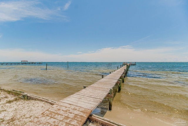 view of dock featuring a water view and a view of the beach