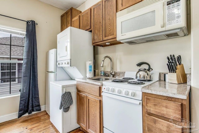 518 W Strong St Unit A & B, Pensacola, FL 32501 - kitchen featuring white appliances, light countertops, a sink, stacked washing maching and dryer, and brown cabinets