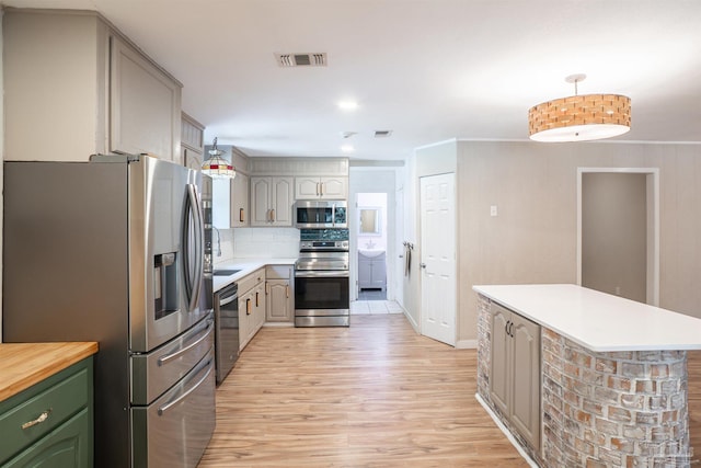 kitchen with gray cabinetry, pendant lighting, and stainless steel appliances