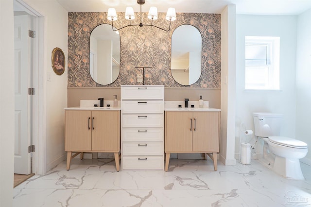 bathroom featuring vanity, toilet, and a notable chandelier