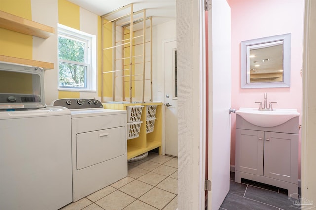 clothes washing area featuring sink, light tile patterned floors, and washer and clothes dryer