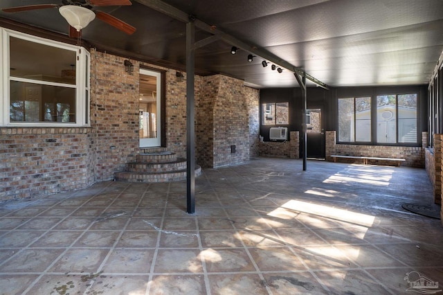 unfurnished sunroom featuring ceiling fan and rail lighting