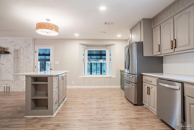 kitchen with gray cabinets, stainless steel dishwasher, and light wood-type flooring