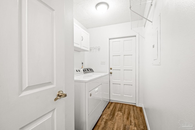 laundry room featuring a textured ceiling, washer and dryer, cabinets, and dark wood-type flooring