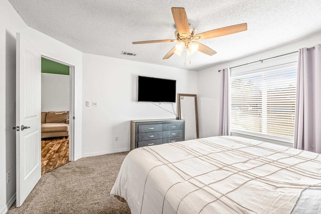 bedroom featuring carpet, ceiling fan, and a textured ceiling