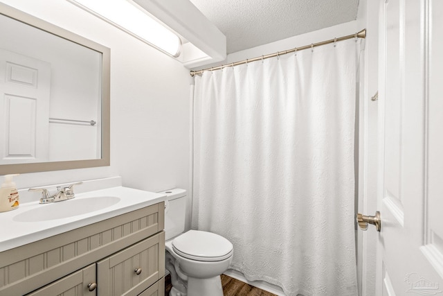 bathroom with hardwood / wood-style floors, vanity, a textured ceiling, and toilet